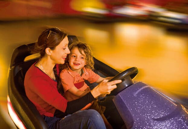 Mother and child driving dodgems at The Milky Way, a top family attraction near Bude in Devon